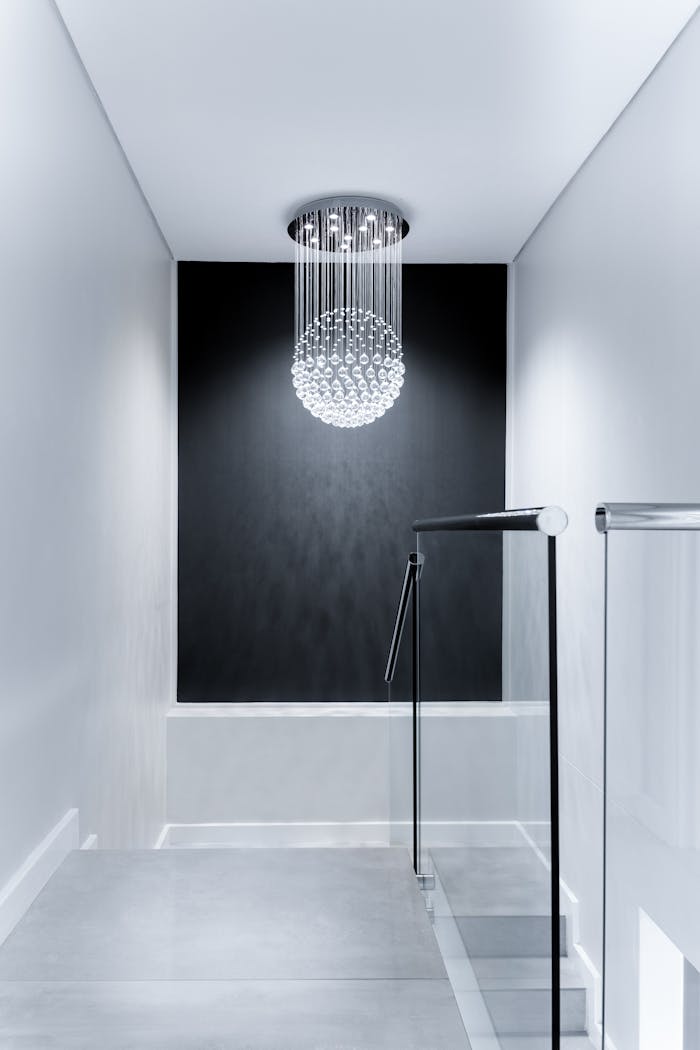 services-03 Sleek contemporary hallway featuring a stunning glass chandelier and minimalist design.