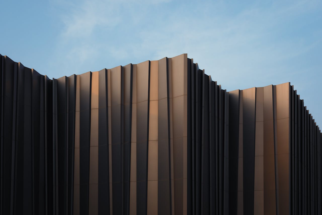 services-02 Sleek modern building facade with unique design set against a clear blue sky.